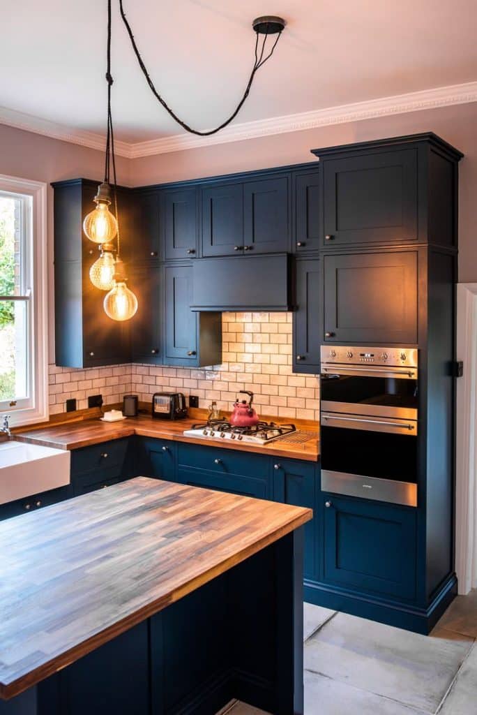 Transform Your Home with Stunning Decorative Pendants Today. 9 Blue kitchen with three industrial-style pendants