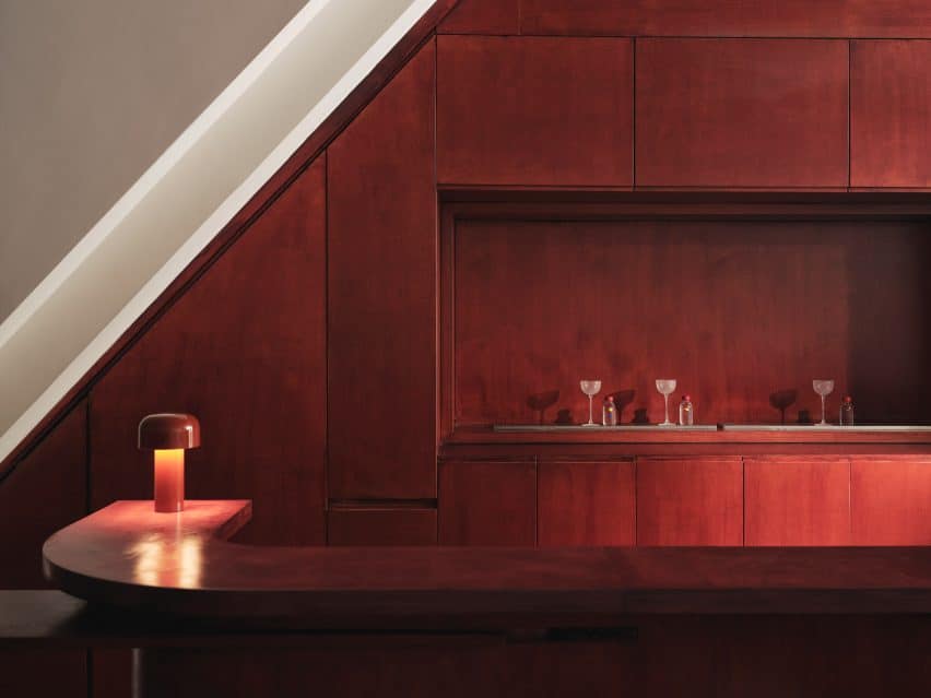 Cake Architecture created a smooth ground-floor bar from reddish plywood.