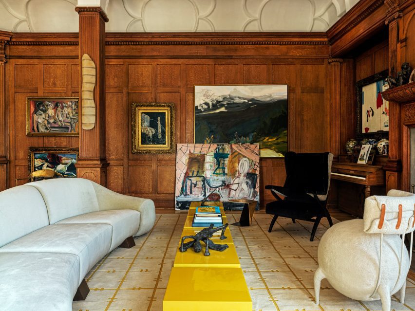 Eccentric Redesign of Historic Tribeca Penthouse by Crina Arghirescu Rogard 2 The grand living room showcasing walnut panelling, bold furniture, and extensive artwork.