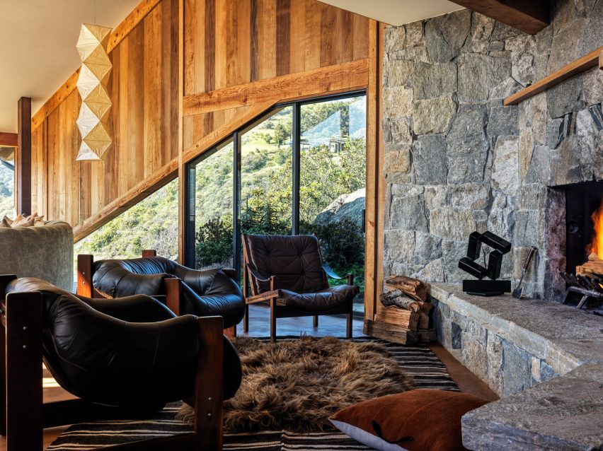 Vintage leather chairs surrounding a prominent stone hearth.