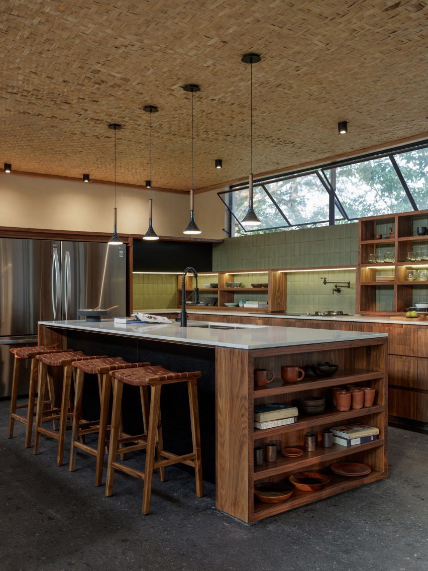 Image of Espacio Kaab, a kitchen designed using natural materials like stone floors, wooden cabinets, and woven carrizo ceilings.