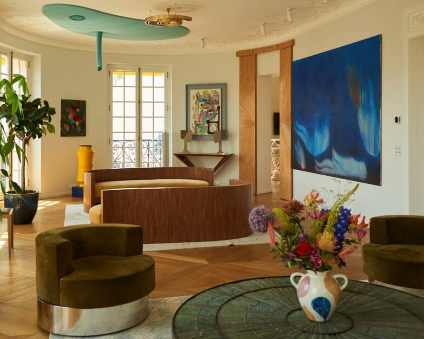 The living room showcases various artworks, blending eclectic furniture pieces.