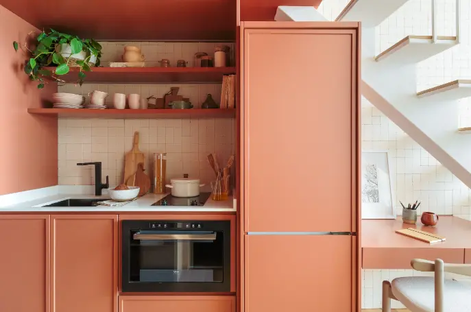 A mini terracotta kitchen with shelves, storage space, and an embedded fridge in the cabinetry – Project: SP Estúdio Arquitetura | Photo: Felco