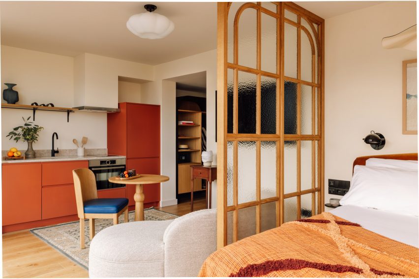 Transformation of a Historic Convent into the Locke de Santa Joana Hotel in Lisbon 5 Suite with wood partition wall that divides spaces within the suite-style room.