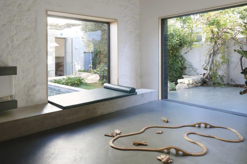 Maison Jericho features a concrete window seat overlooking a tiled terrace and pool, with a leather daybed for comfort.