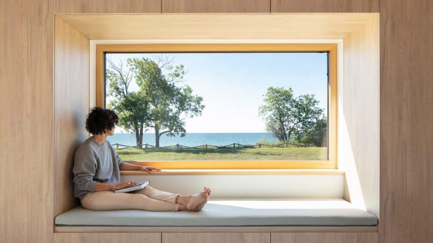 A wooden window seat offers a picturesque view of Lake Ontario in Ell House, designed by Ravi Handa Architect and AAmp Studio.