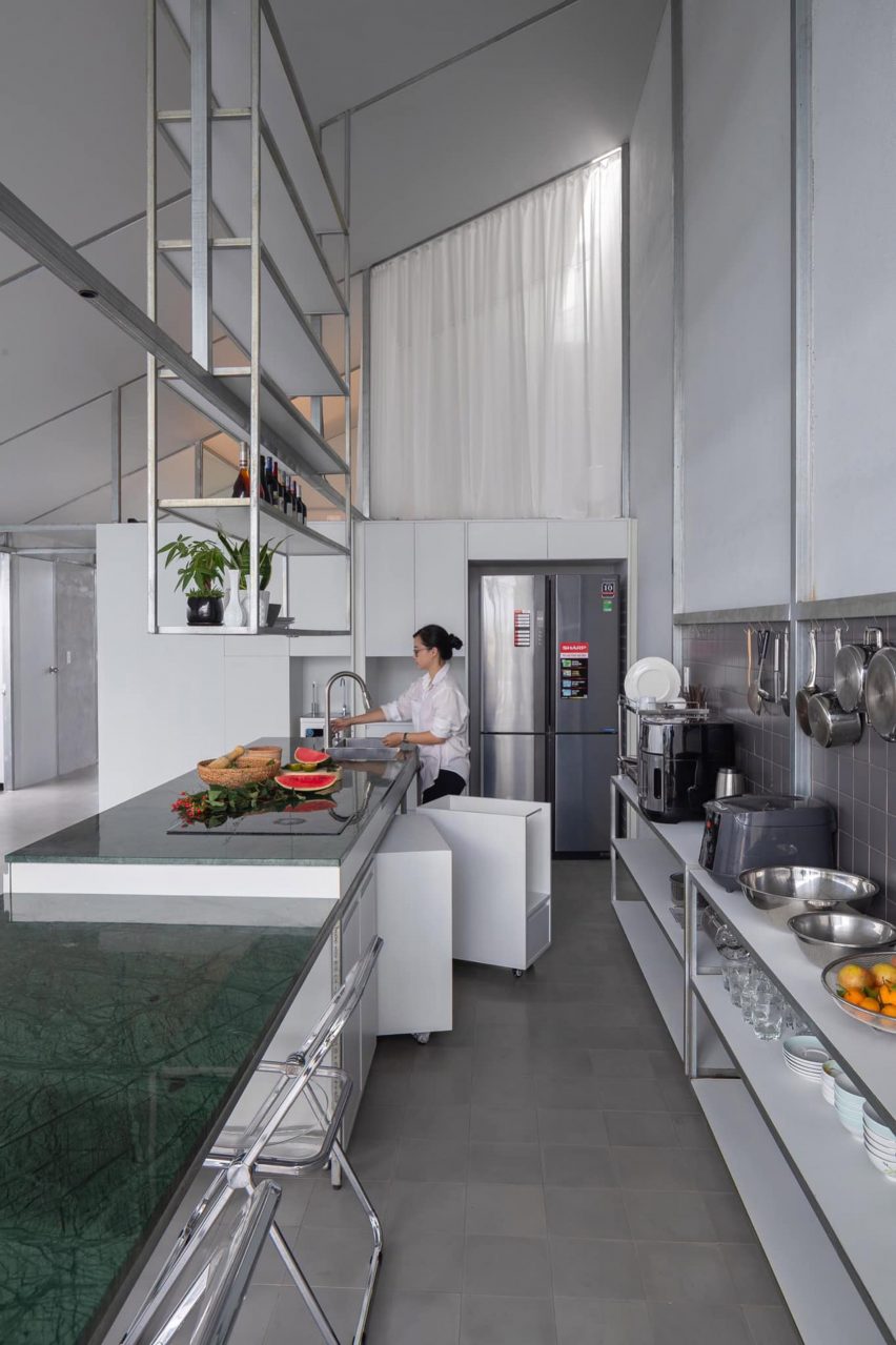 Binh Thuan House by MIA Design Studio employs an industrial feel with an exposed steel frame and simple white curtains.