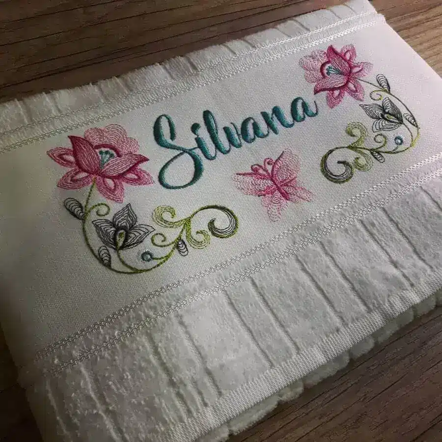Stunning Embroidered Towels: 60 Unique Design Ideas Revealed. 1 Embroidered towel with name and flowers – Photo: Ateliê Liz Poá