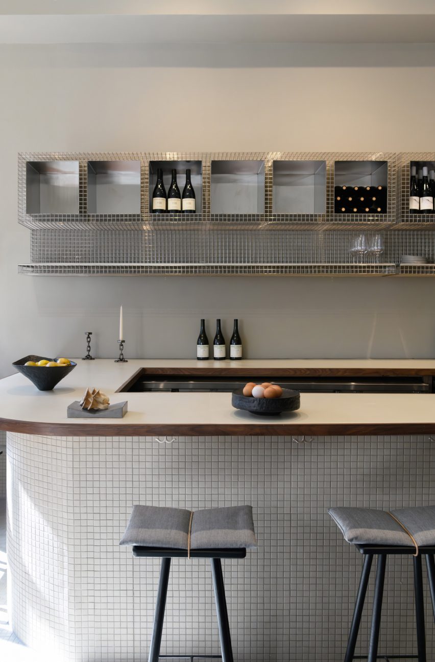 Bar counter featuring industrial-style metal-mesh shelving and a calm aesthetic.