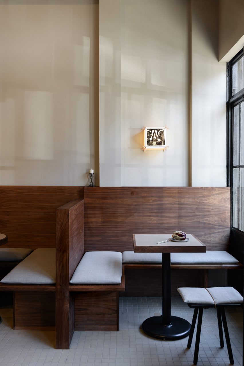 Close-up of walnut banquettes designed for comfort with tall backs and thin cushions.