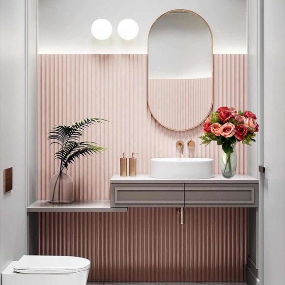 Bathroom with pink rips and oval mirror with rose gold border
