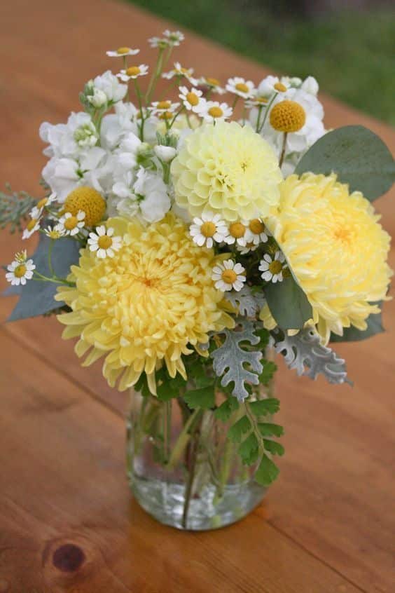 Glass vase with white and yellow wildflowers