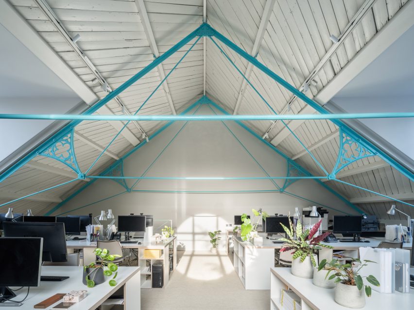 Tigg + Coll Architects Rehabilitate a Victorian Church into Modern Studios 4 Interior view focusing on original steel trusses that are featured prominently in turquoise color.