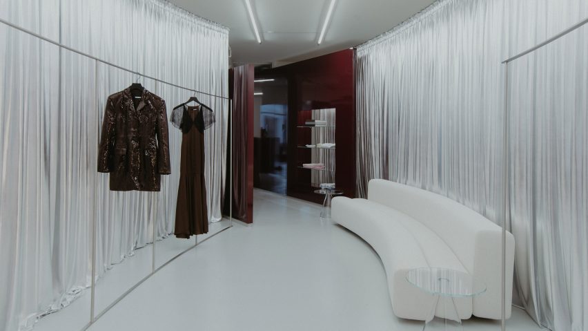 Silver curtains frame an oval room.