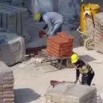 Canteiro de obra em ação, mostrando a movimentação dos trabalhadores e materiais.