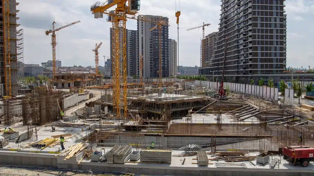 Canteiro de obra com trabalhadores e maquinário, destacando a funcionalidade do espaço.