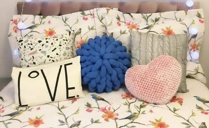 Almofadas de cama com diferentes texturas e cores.