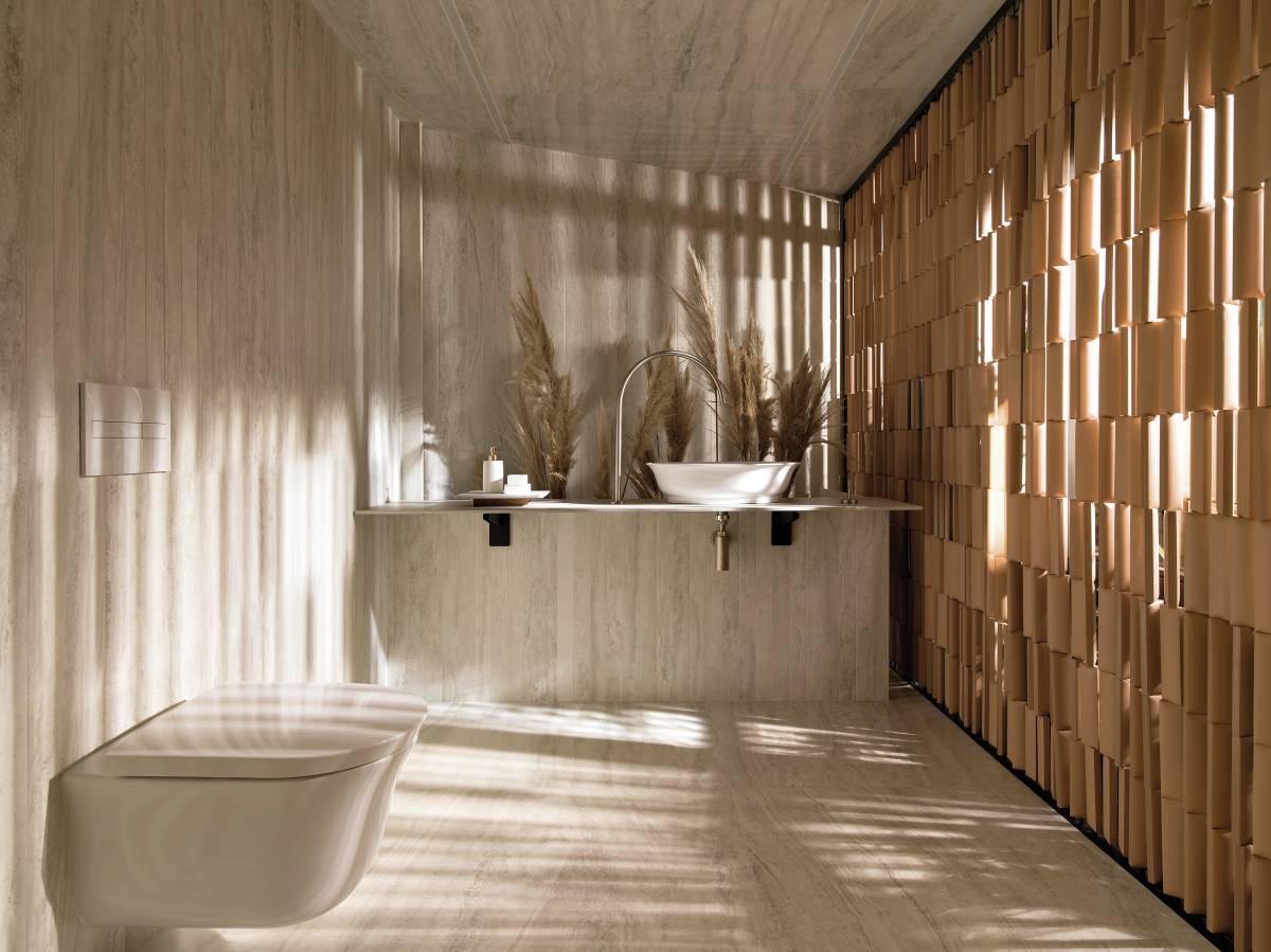 Lavado revestido com porcelanato no piso, paredes e teto. Parede vazada revestida com pequenos formatos cerâmicos permite entrada de luz natural e ventilação.