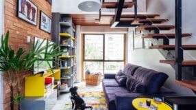 Móveis coloridos em ambiente com revestimento cinza.