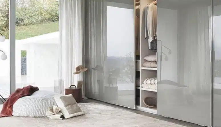 Guarda-roupa planejado em madeira clara com espelhos integrados.