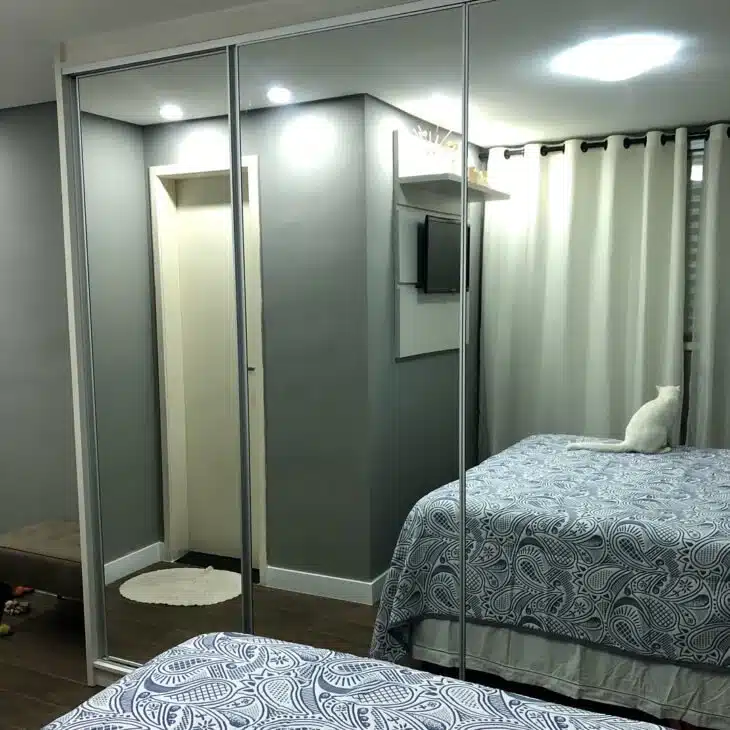 Guarda-roupa espelhado que traz um efeito de amplitude ao ambiente.