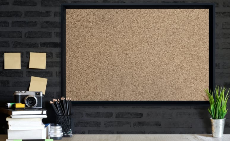 Imagem de um quadro de cortiça com várias fotos e notas coladas.