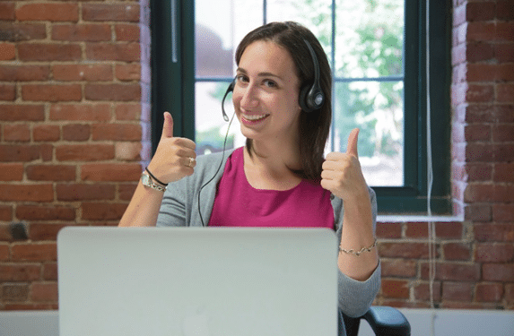 Two Essential Steps for Architects to Attract More and Better Clients 5 Imagem de uma modelo fotográfica fazendo sinal de positivo em frente a um notebook gigante.