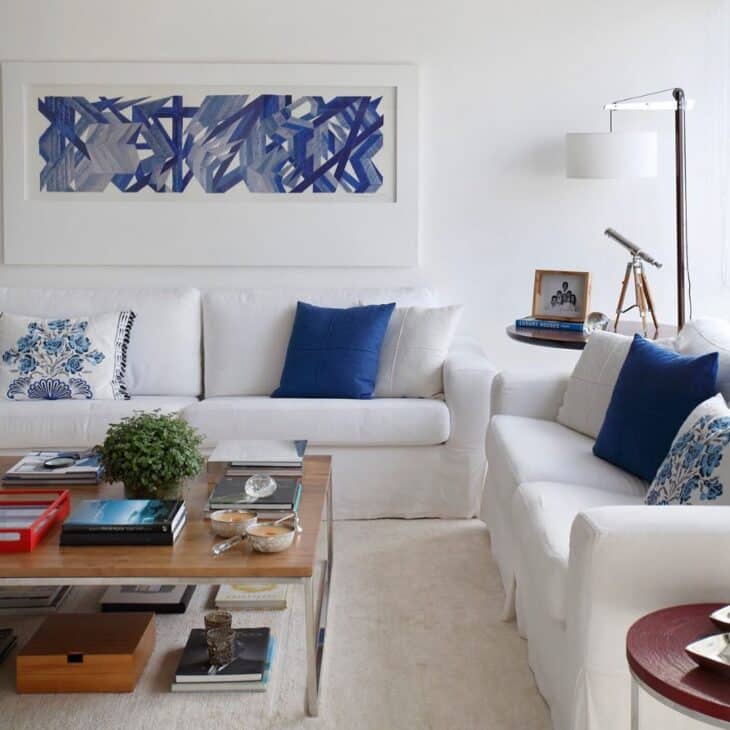 70 Elegant Ideas to Embrace the White Sofa 2 Composição harmônica com sofá branco e decoração azul.