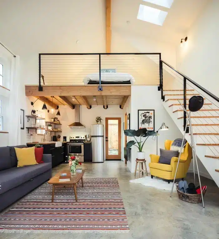 Transform Your Studio Apartment into a Stunning Loft: Expert Tips and Tricks 5 Imagem de um loft com paredes de tijolos expostos e grandes janelas, destacando a iluminação natural.