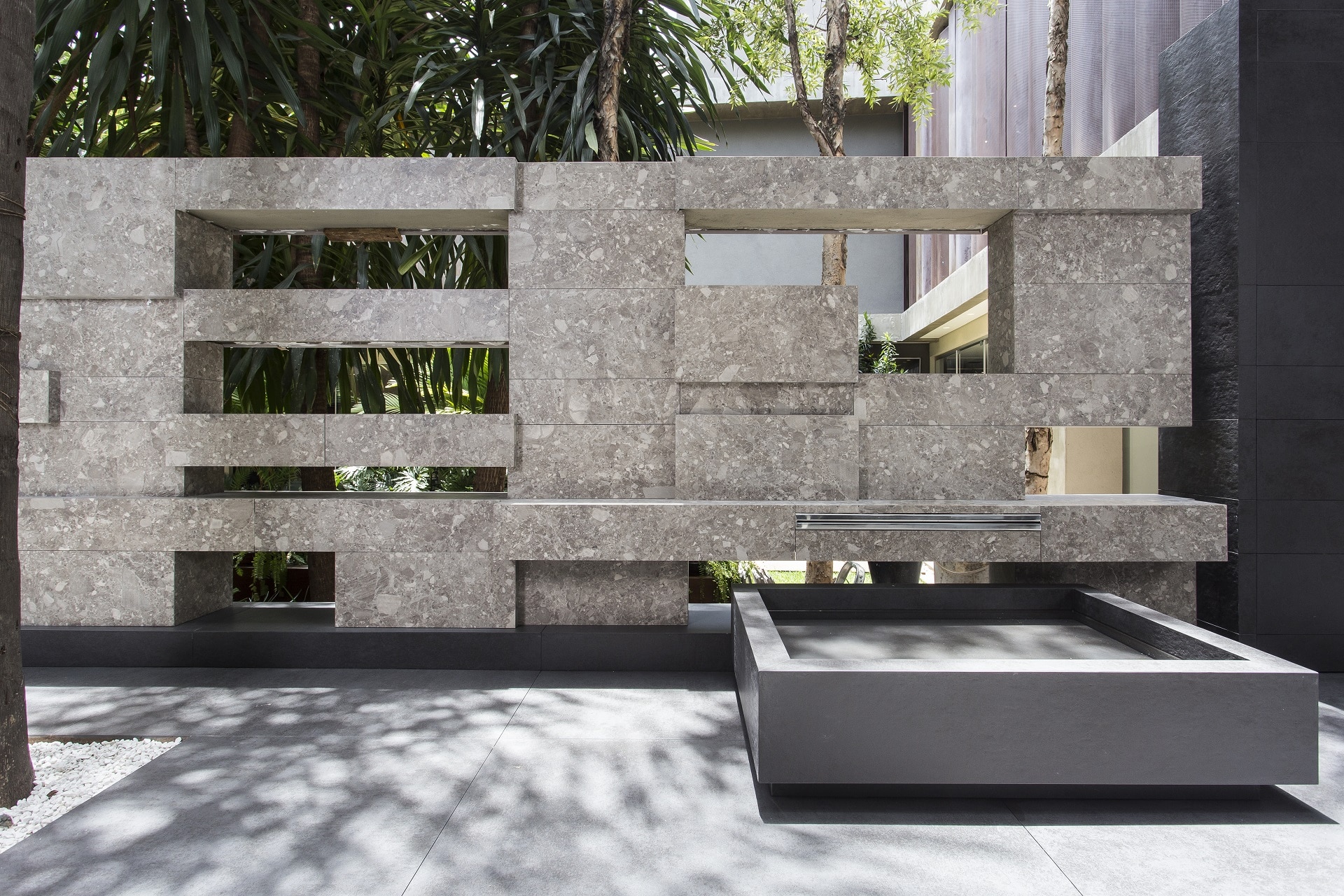 Reprodução de pedra com seixos leva personalidade ao muro com porcelanato.