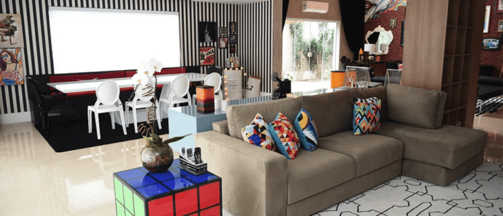 Salas de estar e jantar integradas com tapete e mesa lateral.