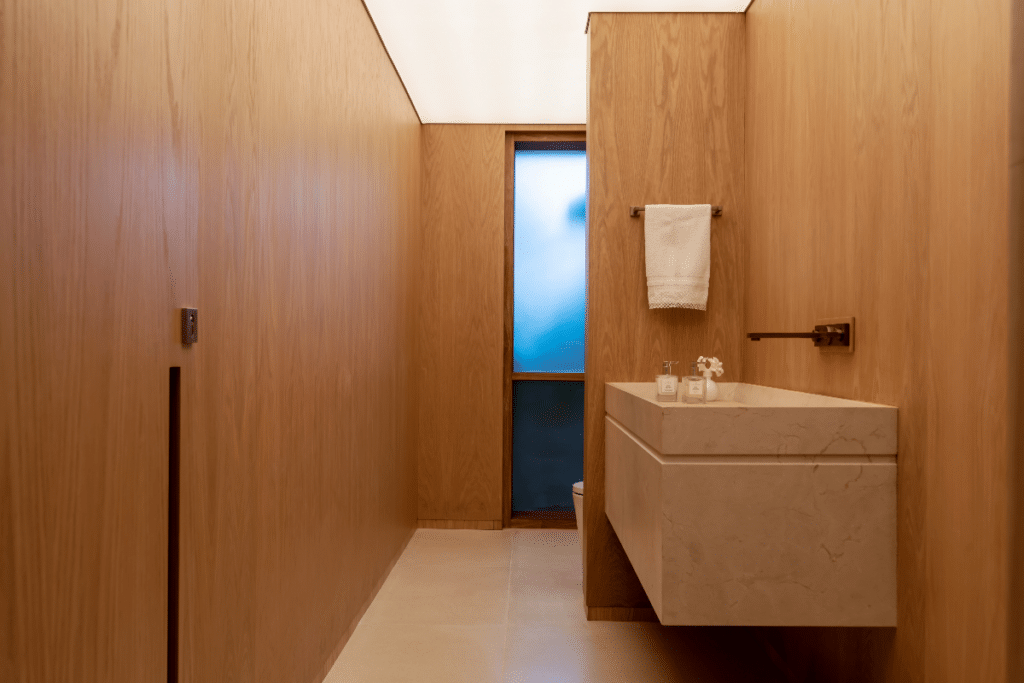Lavabo com paredes revestidas por madeira de carvalho. Clean e muito elegante, este lavabo, todo revestido em madeira de carvalho, recebe quem chega com muito estilo.