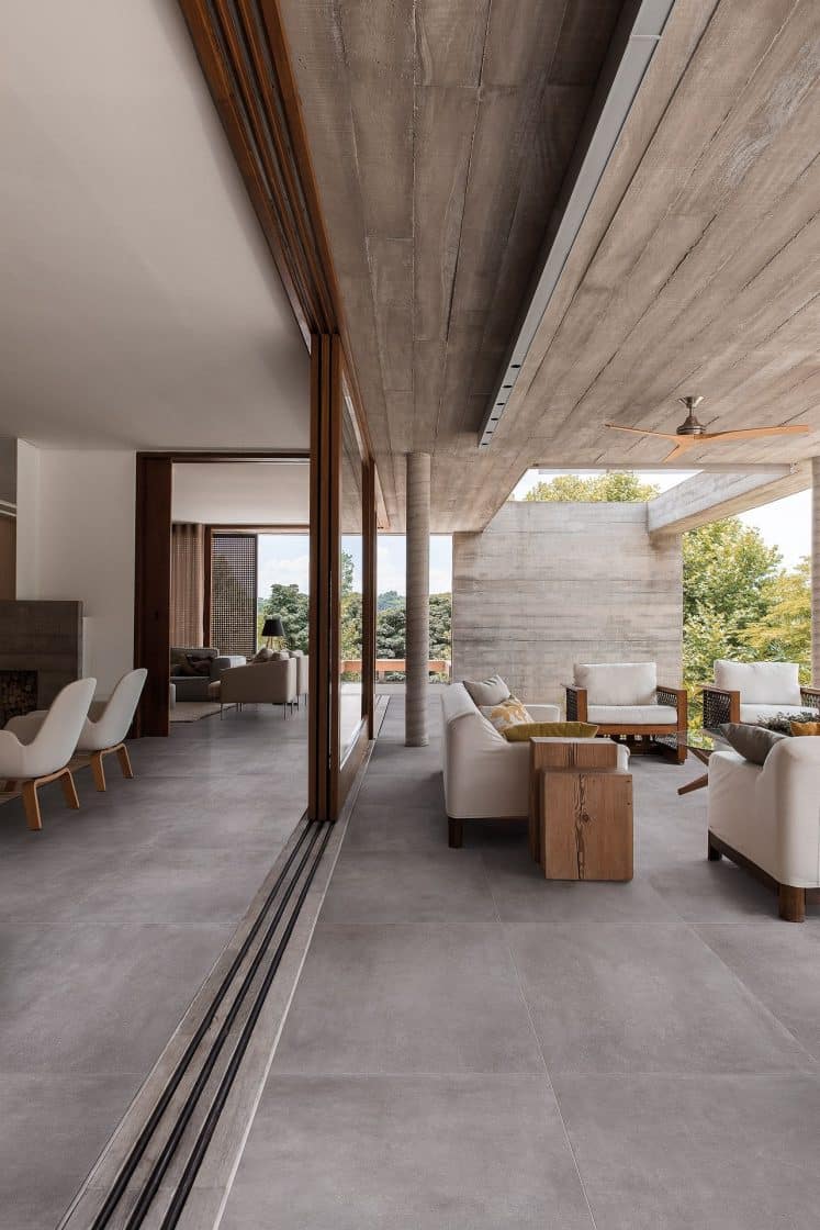 Ambiente in and out com materiais como concreto e madeira