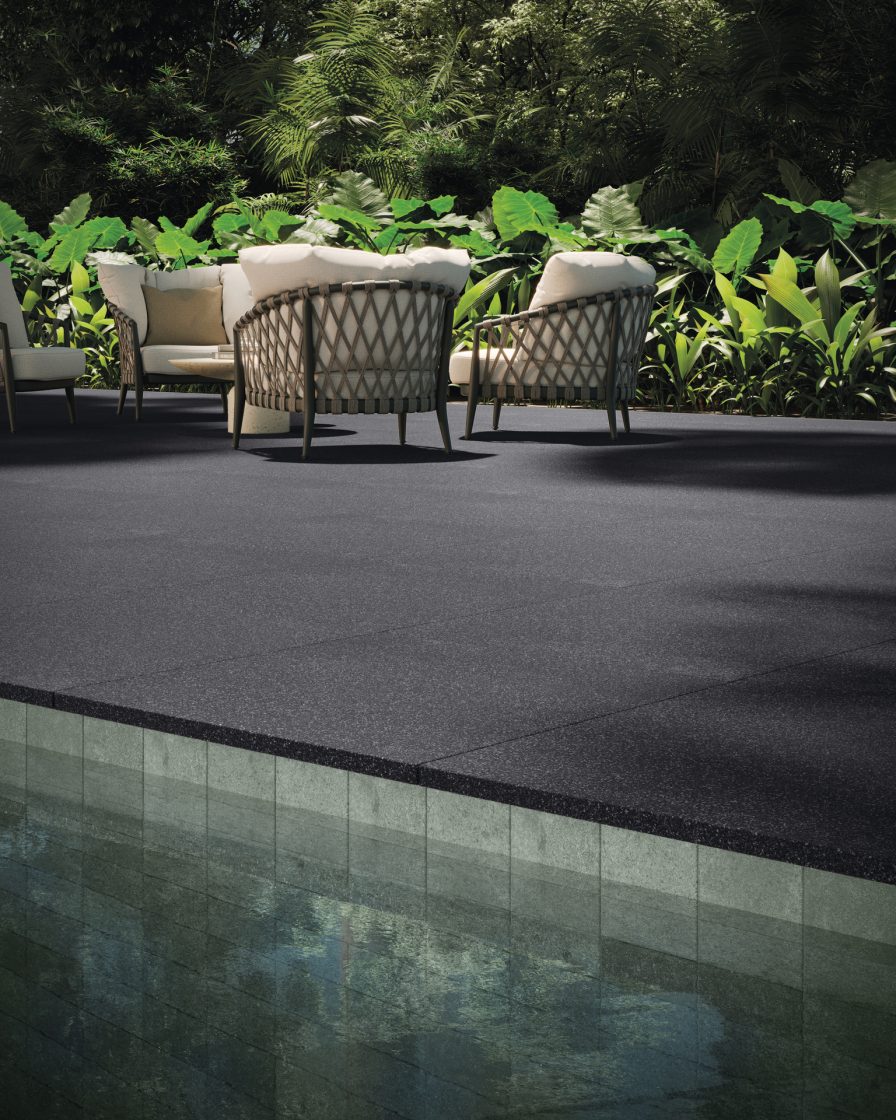Outdoor Flooring: Discover the Best Options 3 Imagem de borda de piscina, piso atérmico na cor grafite, cadeiras e vegetação ao fundo