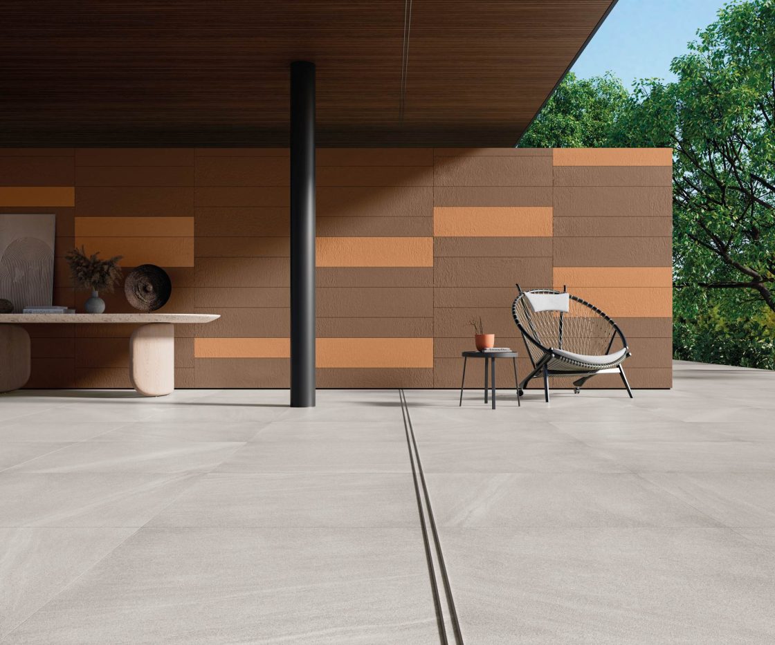 Outdoor Flooring: Discover the Best Options 5 Varanda integrada com porcelanato, parede com tons terrosos e vegetação abundante, móveis contemporâneos e design minimalista