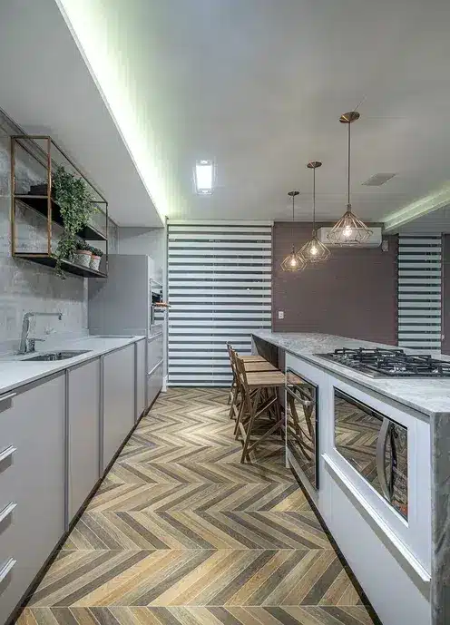Fish Scale vs. Herringbone Patterns: Key Differences and Inspirations 9 Cozinha com um piso em paginação espinha de peixe com cores diferentes em tons cinzas e marrom.