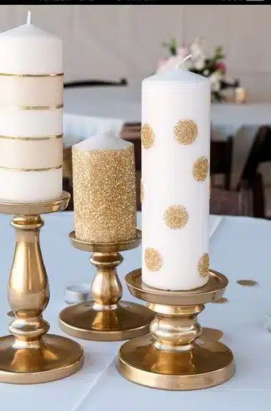 Vela branca decorada com fitas coloridas e glitter.