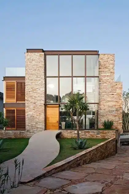 9 Facade Inspiration Ideas to Find Your Dream Home Style 7 Fachada em harmonia com materiais rústicos, visando uma captação natural da luz solar.