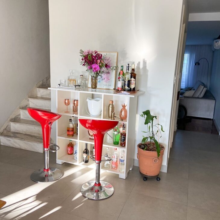 Um minibar bem organizado com copos e garrafas.