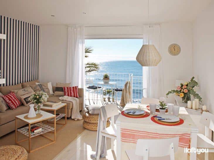 Foto de um pequeno apartamento de praia decorado, mostrando a sala de estar com vista para o mar.