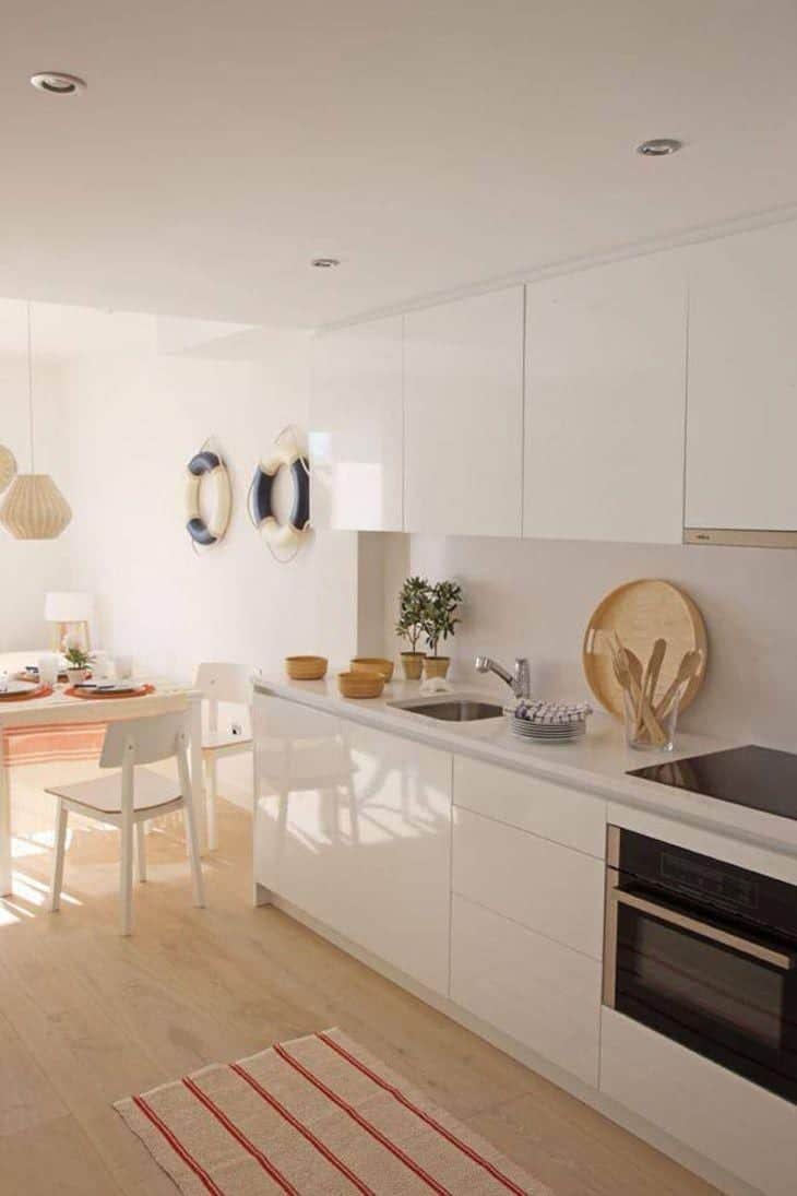 Foto da varanda do apartamento, com mesa e cadeiras brancas.