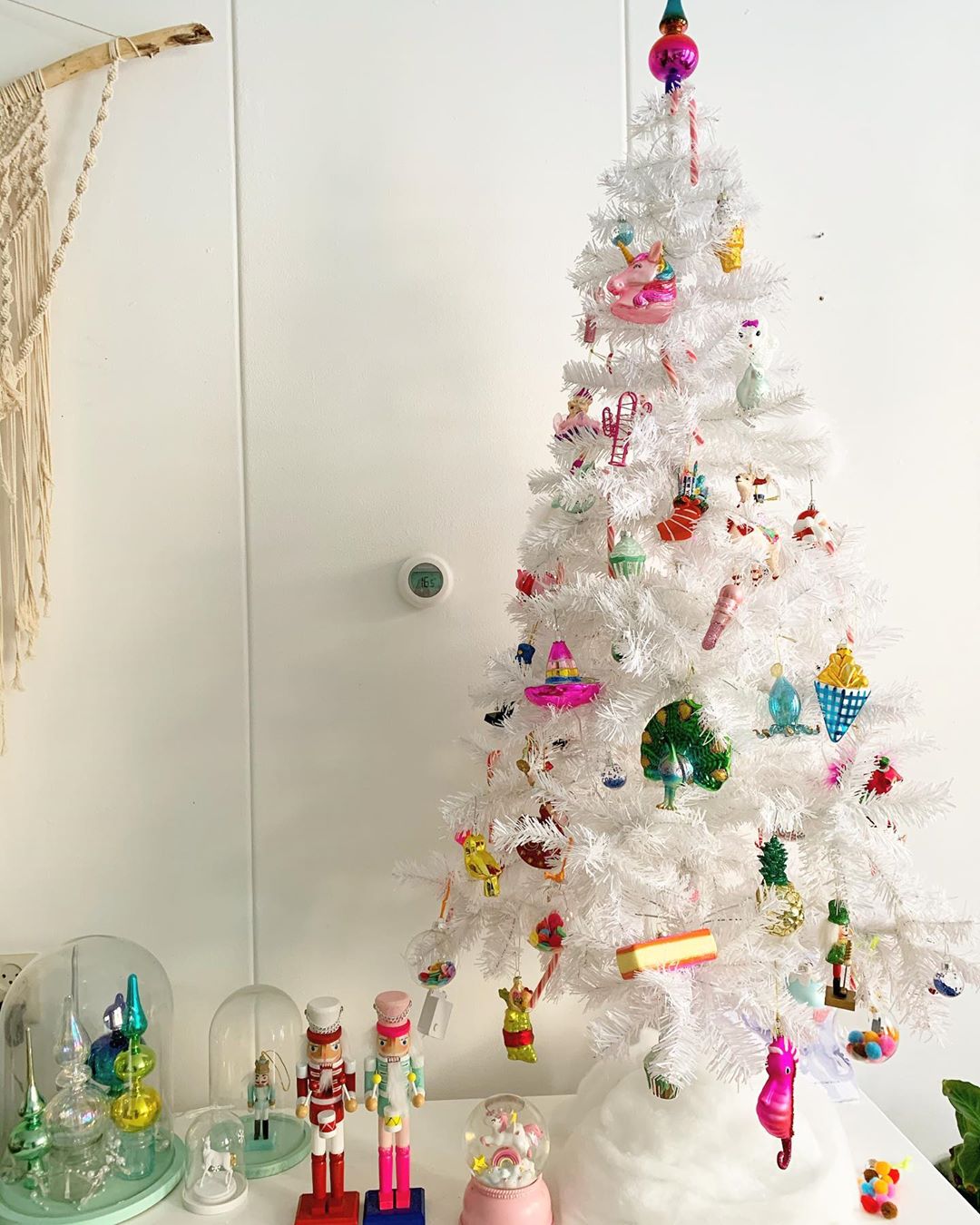 Modelo de árvore de Natal branca com tons suaves de azul e rosa.