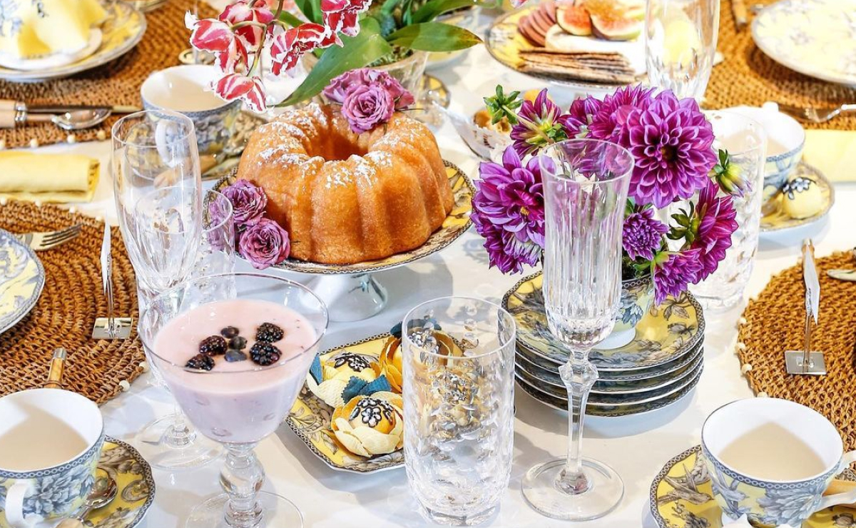 Mesa de café da manhã decorada e cheia de alimentos gostosos.