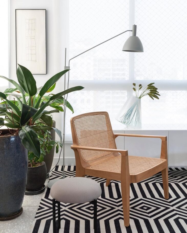 Imagem de uma poltrona para leitura em um ambiente com plantas.