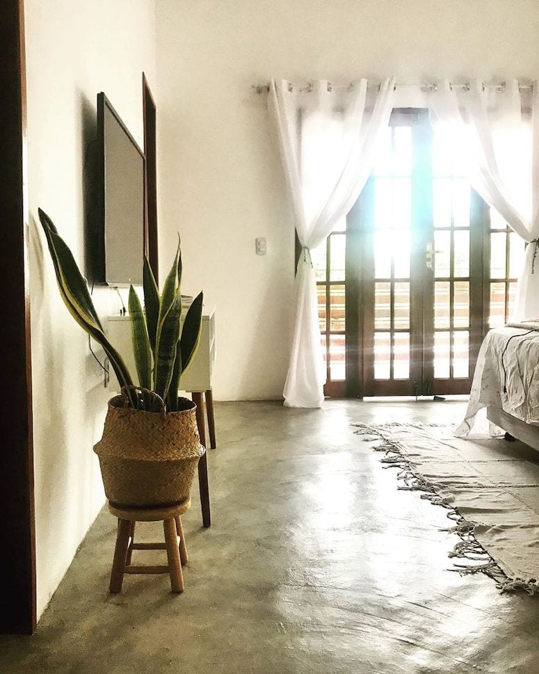 Quarto rústico com piso de madeira e elementos naturais.
