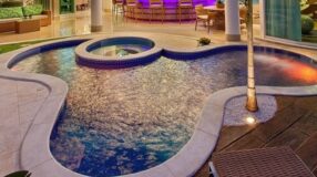 Foto de uma piscina com hidro que demonstra um espaço relaxante.